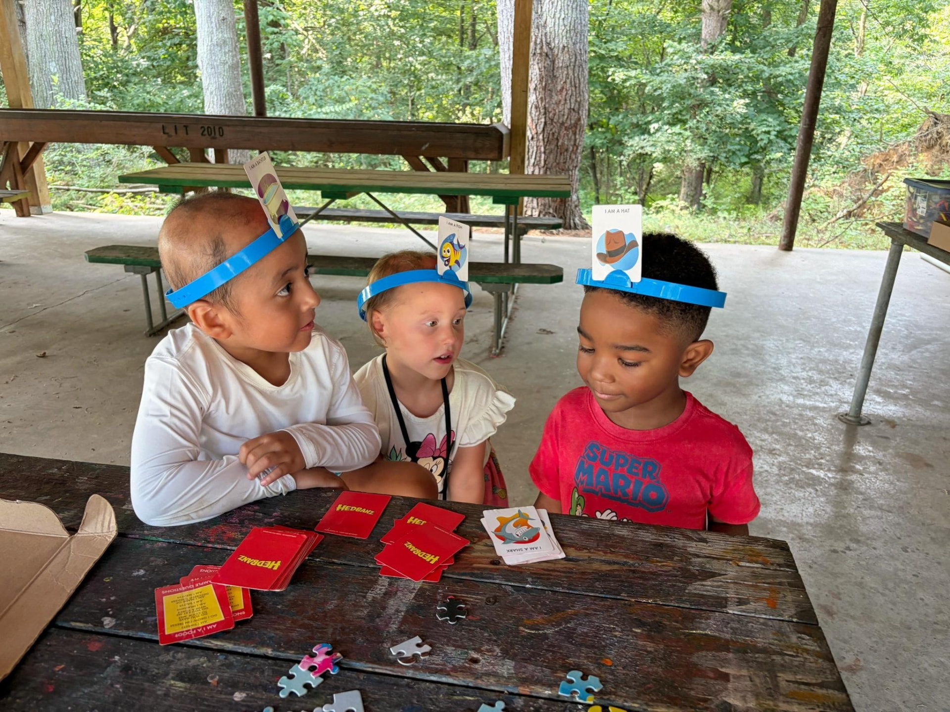 CAP campers playing a headband card game together at camp