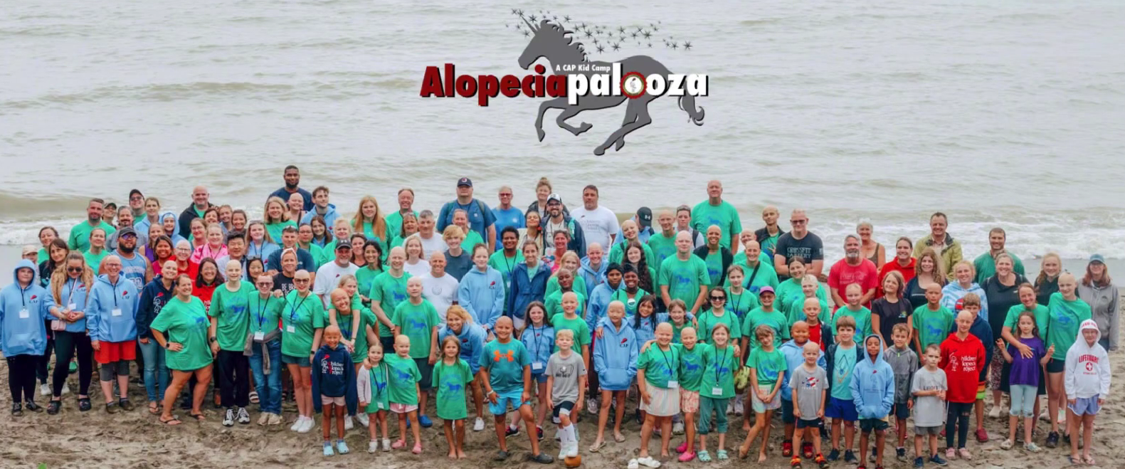 Alopeciapalooza attendees gathered on the beach for a group photo